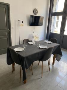 una mesa con sillas y un mantel negro. en Le Merrain gîte plein coeur de Chablis, en Chablis