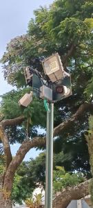 a security camera on a pole in front of a tree at CASA HOTEL FLOR DEL VALLE in Cali +55 photos