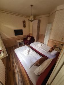 a hotel room with two beds and a television at Guesthouse Yildiz in Sarajevo