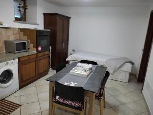 una cucina con letto e tavolo con sedie di Villa Anna - La Dependance a Saint-Christophe
