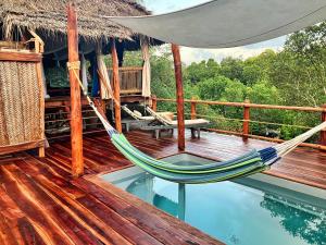 a hammock on a deck next to a swimming pool at Chole Mjini Treehouses Lodge in Utende