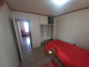 1 dormitorio con 1 cama con manta roja en Doña Nancy en Temuco