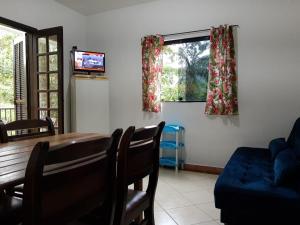 a living room with a table and a couch and a television at Recanto do italiano in Ubatuba
