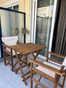 a wooden table and two chairs on a porch at yourcomfortzone*VOLOS in Volos