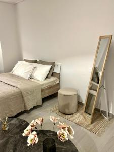 a bedroom with a bed and a mirror and flowers at yourcomfortzone*VOLOS in Volos +12 photos