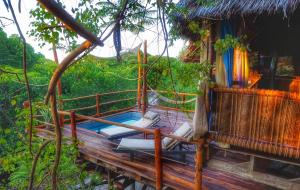 a porch of a house with a swing at Chole Mjini Treehouses Lodge in Utende