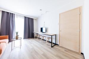 een woonkamer met een tafel en stoelen en een schuifdeur bij Saaremaa Rannahotell ' Beach Hotel in Mändjala