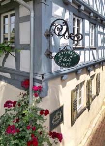 um sinal na lateral de um edifício com flores em Stevenson House Bed and Breakfast em Oberderdingen