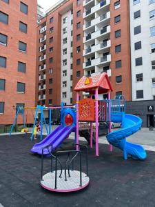 un parque infantil con toboganes coloridos y una estructura de juegos en Modern Apartment en Ferizaj