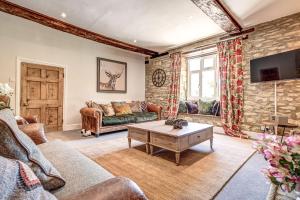 ein Wohnzimmer mit einem Sofa und einem Tisch in der Unterkunft Greenhill Farmhouse in Bletchingdon