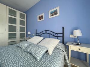 Dormitorio azul con cama y escritorio en Apartamento Alameda del Tajo III Centro Parquing, en Ronda