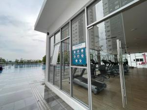 a building with a gym with treadmills and a pool at Gembira Alanis by H Family #KLIA #Wifi #Netflix in Sepang