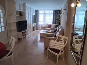 un soggiorno con divano, sedie e specchio di Club Excelsior II a Playa del Ingles