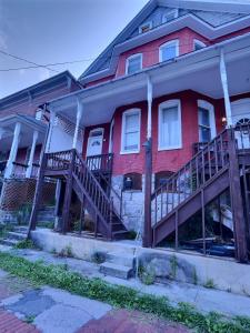 una casa de ladrillo rojo con escaleras de madera delante en 1900s Downtown Rowhouse, walkable, historic, pet friendly, spacious. en Cumberland