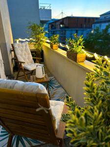 d'un balcon avec des chaises et des plantes dans un bâtiment. dans l'établissement Le perchoir du stade by UTA HOUSE, à Saint-Denis
