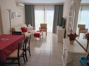 sala de estar con sofá y mesa con mantel rojo en Club Excelsior II, en Playa del Inglés