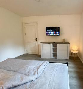 a bedroom with a bed and a tv on the wall at Pidder Lüng in Bargum