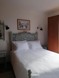 a bedroom with a bed with a white bedspread and aintendent at Casa da Canada da Fajã in Feteira