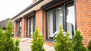 une maison en briques avec des fenêtres et des fleurs dans une cour dans l'établissement Casa Caso - Apartment 3, à Achim