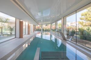 an indoor swimming pool in a building with windows at JS Portocolom Suites in Portocolom
