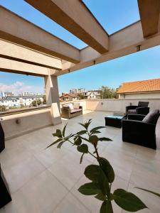 a patio with couches and chairs on a roof at Mamaia Moments Villa, Mamaia Nord in Mamaia Nord