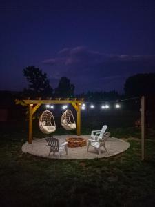 a gazebo with two chairs and a fire pit at night at Vikendice Gornja Brezna - Mountain cabin Gornja Brezna in Pluzine