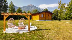 a cabin in a field with two chairs in front of it at Vikendice Gornja Brezna - Mountain cabin Gornja Brezna in Pluzine