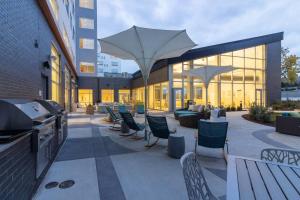 eine Terrasse mit Stühlen und Sonnenschirmen auf einem Gebäude in der Unterkunft Element St. Louis Midtown in Saint Louis