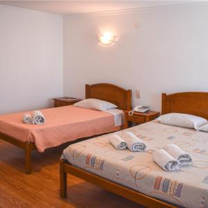 2 Betten in einem Hotelzimmer mit Handtüchern darauf in der Unterkunft Autentisereia in Algoso