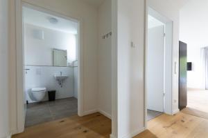 uma casa de banho branca com um WC e um lavatório em T&K Apartments - Bergisch Gladbach - 7 Comfortable Apartments - 20 min to Fair Messe Cologne em Bergisch Gladbach