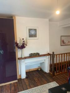 a living room with a fireplace with a vase of flowers at One Lovely Apartmt 1 Double & 2 Camp Beds in Stoke on Trent