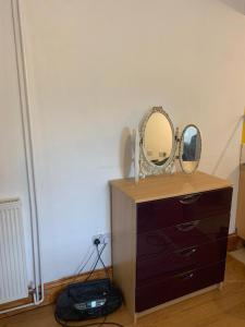 a dresser with two mirrors on top of it at One Lovely Apartmt 1 Double & 2 Camp Beds in Stoke on Trent