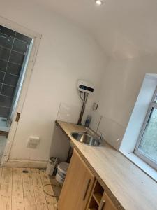 Elle comprend une petite cuisine avec un évier et une fenêtre. dans l'établissement One Lovely Apartmt 1 Double & 2 Camp Beds, à Stoke-on-Trent