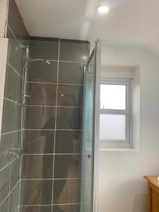 une personne prenant une photo d'une douche dans une salle de bains dans l'établissement One Lovely Apartmt 1 Double & 2 Camp Beds, à Stoke-on-Trent