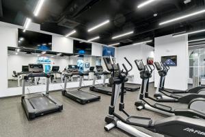 a gym with rows of treadmills and elliptical machines at Calypso Beach Resort & Towers by Panhandle Getaways in Panama City Beach