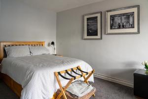 a bedroom with a bed and two pictures on the wall at Nr WINDSOR stunning 1 bedroom self contained property in Burnham near Heathrow in Burnham