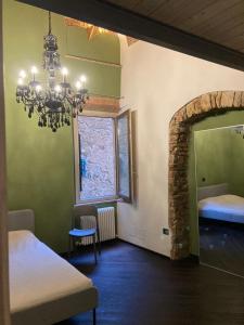 Cette chambre comprend deux lits et un lustre. dans l'établissement CASA GINESTRA, à Campiglia Marittima
