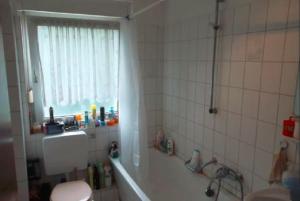 a bathroom with a tub and a toilet and a window at Düsseldorf - separates, privates Zimmer in Düsseldorf