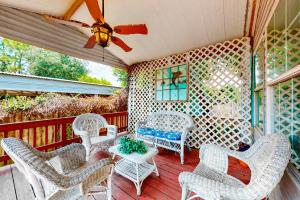 un porche con mesa y sillas blancas de mimbre en Laguna Hideaway, en Panama City Beach