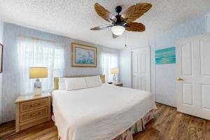 a bedroom with a bed and a ceiling fan at Laguna Hideaway in Panama City Beach