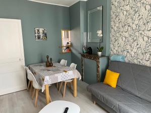 a living room with a table and a couch at Villa Liliane appartement de 55 m2 in Mers-les-Bains