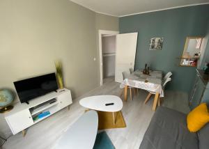 a living room with a couch and a tv at Villa Liliane appartement de 55 m2 in Mers-les-Bains