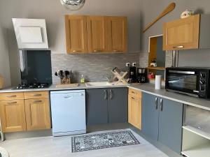 a kitchen with wooden cabinets and a white dishwasher at Villa Liliane appartement de 55 m2 in Mers-les-Bains +2 photos