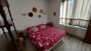 Un dormitorio con una cama roja con sábanas de lunares. en 20 Rue Châtel, en Verdún