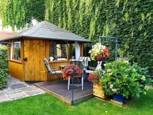 a wooden deck with a gazebo with a table and chairs at Pension Wehner in Torgau
