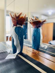 dos jarrones azules con flores en una mesa en Casa Cabilao Staycation, en Santa Rosa