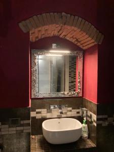 La salle de bains est pourvue d'un lavabo blanc et d'un miroir. dans l'établissement CASA GINESTRA, à Campiglia Marittima