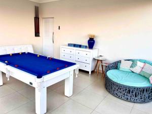 - un salon avec une table de billard et une chaise dans l'établissement Casa dos sonhos, relaxar Ninho Verde 1 com Piscina, à Quadra