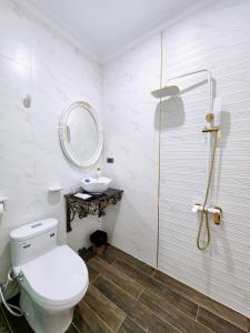 a bathroom with a toilet and a sink and a mirror at Paris Hotel & Cafe in Vĩnh Long
