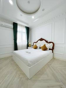 ein Schlafzimmer mit einem großen weißen Bett in einem Zimmer in der Unterkunft Paris Hotel & Cafe in Vĩnh Long